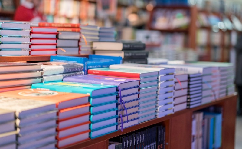 Fotografía de libros apilados en stock, simbolizando la gestión eficiente de distribución de libros y entrega puntual de productos impresos.
